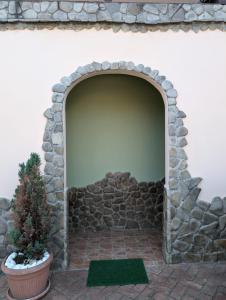 a stone archway with a plant in a pot at Casa Helen House, Iasi in Valea Adîncă