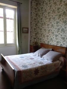 a bedroom with a bed with a floral wallpaper at Grande Maison Simone-Climatisation-Parking-Terrain in Carcassonne