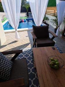 a living room with a table and a pool at Happy Vecation in Tuzla