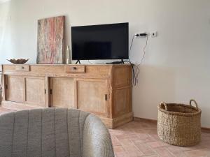 einen TV auf einem Holzschrank im Wohnzimmer in der Unterkunft Quinta do Coelhoazul in Quelfes