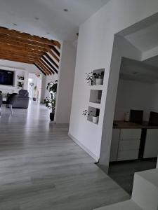 a living room with white walls and wooden floors at Happy Vecation in Tuzla