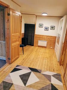 an empty room with a rug on a wooden floor at Loghouse apartment in arctic wonderland! in Kvaløya +90 photos