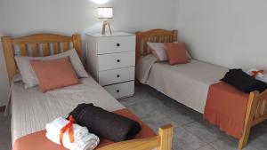 a bedroom with two beds and a dresser at Apart Los Naranjos in Chajarí