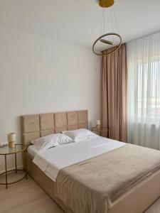 a bedroom with a large bed with two tables at Cozy Apartment in Bucharest