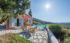 阿约斯尼奇塔斯艾格丽斯尼凯塔斯公寓的房屋前设有带桌椅的天井。