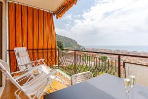 a balcony with chairs and a table and a view at TheKeyStudio, La Casa del Mare Azzurro with seaview in Ventimiglia