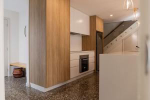a kitchen with a counter and a staircase in it at Baileys Beach House in Binalong Bay