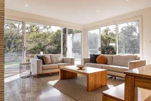 a living room with two couches and a coffee table at Baileys Beach House in Binalong Bay