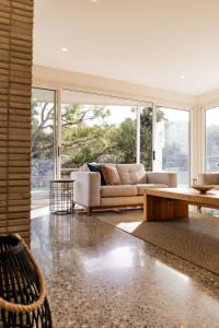 a living room with a couch and a table at Baileys Beach House in Binalong Bay