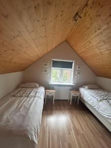two beds in a room with a window at Auðsholt 2 Old House 1930 in Fludir