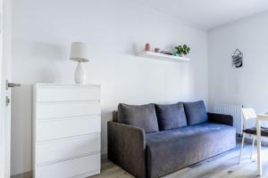 a living room with a blue couch and a dresser at PlumTree Holiday Apartment in Gdańsk