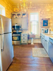 una cucina con frigorifero in acciaio inossidabile e pavimenti in legno di Shopkeeper's Inn a Fredericksburg
