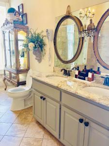 un bagno con due lavandini, un water e uno specchio di Shopkeeper's Inn a Fredericksburg