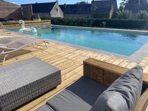 a large swimming pool with a wooden deck and a swimming pool at Grand gîte de Filot in Filot