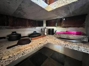 a kitchen counter with pots and pans on it at Surfers Paradise - Cabin next to Yankee Beach in Escamequita