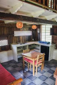 a kitchen with a table and chairs in a room at Surfers Paradise - Cabin next to Yankee Beach in Escamequita