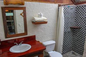 a bathroom with a toilet and a sink and a mirror at Surfers Paradise - Cabin next to Yankee Beach in Escamequita +39 photos
