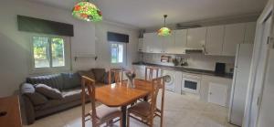 a kitchen and living room with a table and a couch at Lugar das estrelas in Porriño