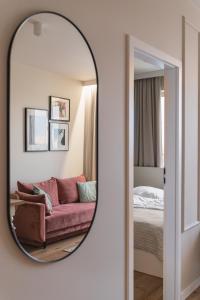a mirror in a room with a couch and a bed at Apartament Pełczyńskiego 3 in Warsaw +10 photos