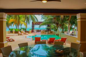 a room with a table and chairs and a pool at Esciros in Chicxulub