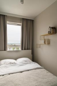 a bedroom with a bed and a window at Apartament Pełczyńskiego 3 in Warsaw