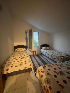 a bedroom with two beds and a window at Apartman Tara in Donji Štoj