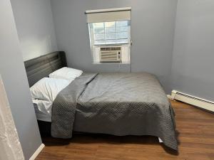 a small bedroom with a bed and a window at Large family home Near NYC in Passaic