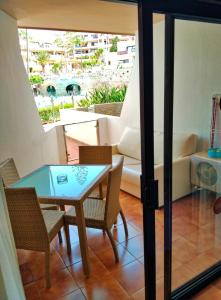 een woonkamer met een tafel, stoelen en een bank bij GOLF MAR SUR ALBATROS 5 bed places apartment in San Miguel de Abona