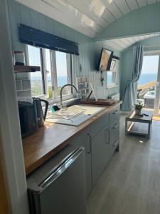 a kitchen with a counter and some windows at Bay View shepherds hut with hot tub in Llanfair