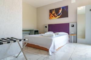 a bedroom with a large white bed with a painting on the wall at Deea Marii Costinesti in Schitul +11 photos