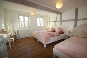 a bedroom with two beds and a desk and two windows at Ferienhaus 140 qm IGELMÜHLE, bei der romantischen Rödermühle an der Fränkischen Saale in Deutschlands Mitte, 8 km zur A7 in Hammelburg +14 photos