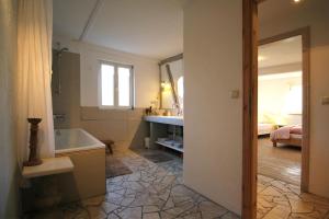 a bathroom with a tub and a sink and a bedroom at Ferienhaus 140 qm IGELMÜHLE, bei der romantischen Rödermühle an der Fränkischen Saale in Deutschlands Mitte, 8 km zur A7 in Hammelburg
