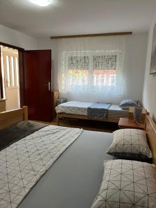 a bedroom with two beds and a window at Apartman Perković in Livno