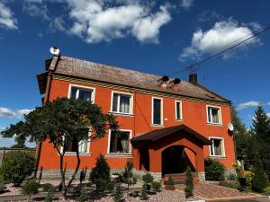 an orange house with a man on top of it at Motel Ararat in Rava-Rusʼka