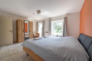 a bedroom with a large bed and a window at Charming Home in Rural Setting with Sauna in Érezée