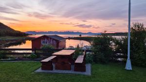 a picnic table and bench in front of a body of water at Prima Lofoten in Myrland