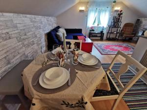 a dining table with plates and glasses on it in a living room at Forest, fishing & relax in Ställdalen
