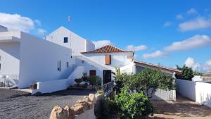 una casa con paredes blancas y una valla en Casa El granero de Antonio, en San Miguel de Abona