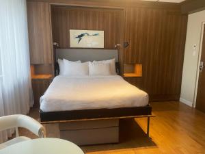 a bedroom with a large bed with white sheets at Hotel Chicoutimi, affili&eacute; &agrave; Hyvi in Saguenay