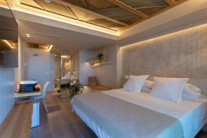 a bedroom with a large white bed and a table at XULOS Rooms & Suites in Peñíscola +86 photos