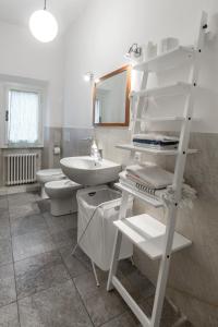 y baño con lavabo, aseo y estante. en Appartamento Cittadella 39, en Florencia