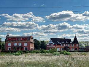 a building with a motel bar on top of a field at Motel Ararat in Rava-Rusʼka