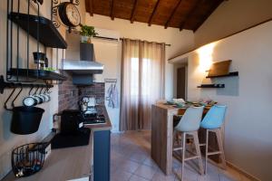 una cucina con un bancone e sgabelli in una stanza di Mariella sul borgo a Ronciglione Altre 18 foto
