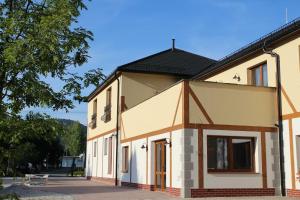 a house with a black roof at Anděl Penzion & Cafe in Rožnov pod Radhoštěm