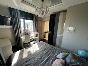 a bedroom with a bed and a chandelier at Marque De Lago in Bucharest +43 photos