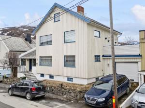 two cars parked in a parking lot in front of a house at Three bedrooms apartment - Central - Lakeview in Hammerfest