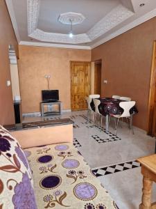 a living room with a couch and a table and chairs at Logement climatisé proche de Fès in El Harmiine