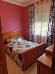 a bedroom with a bed and a window at Logement climatisé proche de Fès in El Harmiine
