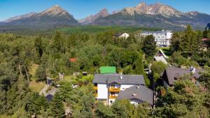 un edificio en medio de un bosque con montañas en Penzion Pažický, en Stará Lesná