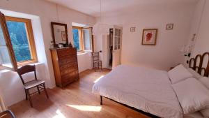 1 dormitorio con cama, silla y vestidor en Antica Villa Piave, en Perarolo di Cadore